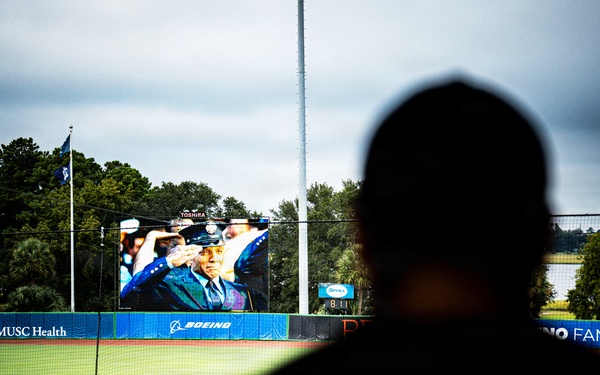 Coast Guard member looks on as scenes from 9/11 play on the center field screen.