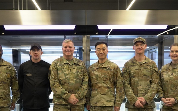 Senior leaders pose inside Camp Walker’s Autonomous Kitchen