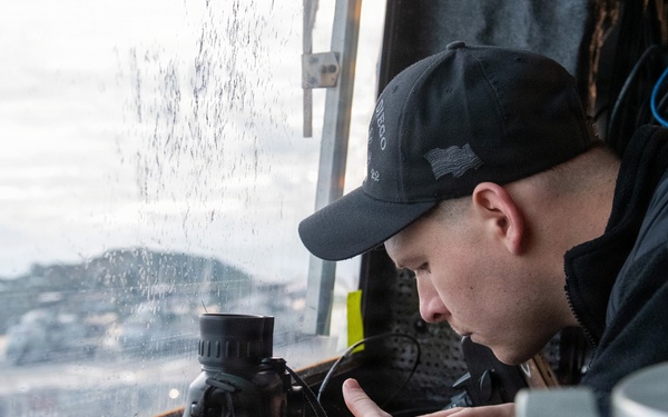 Sailor Prepares Equiptment in Pilothouse