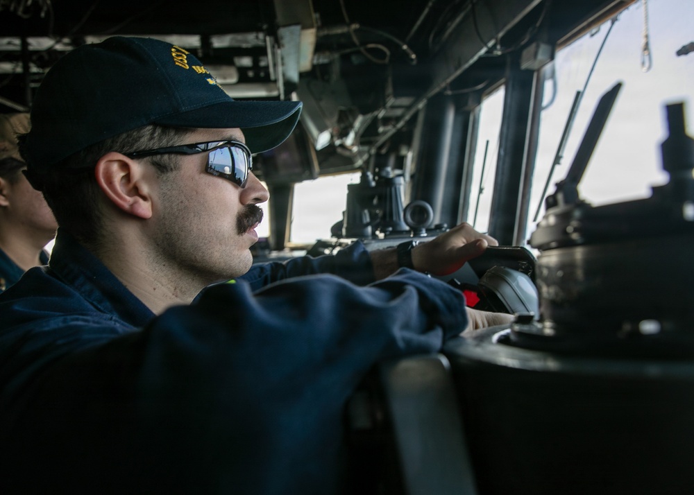 USS Mitscher (DDG 57) junior officer stands watch in ship bridge