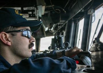 USS Mitscher (DDG 57) junior officer stands watch in ship bridge