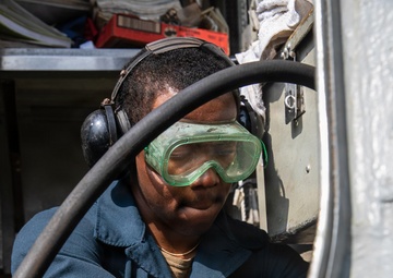 USS Mitscher (DDG 57) Sailor conducts deck preservation