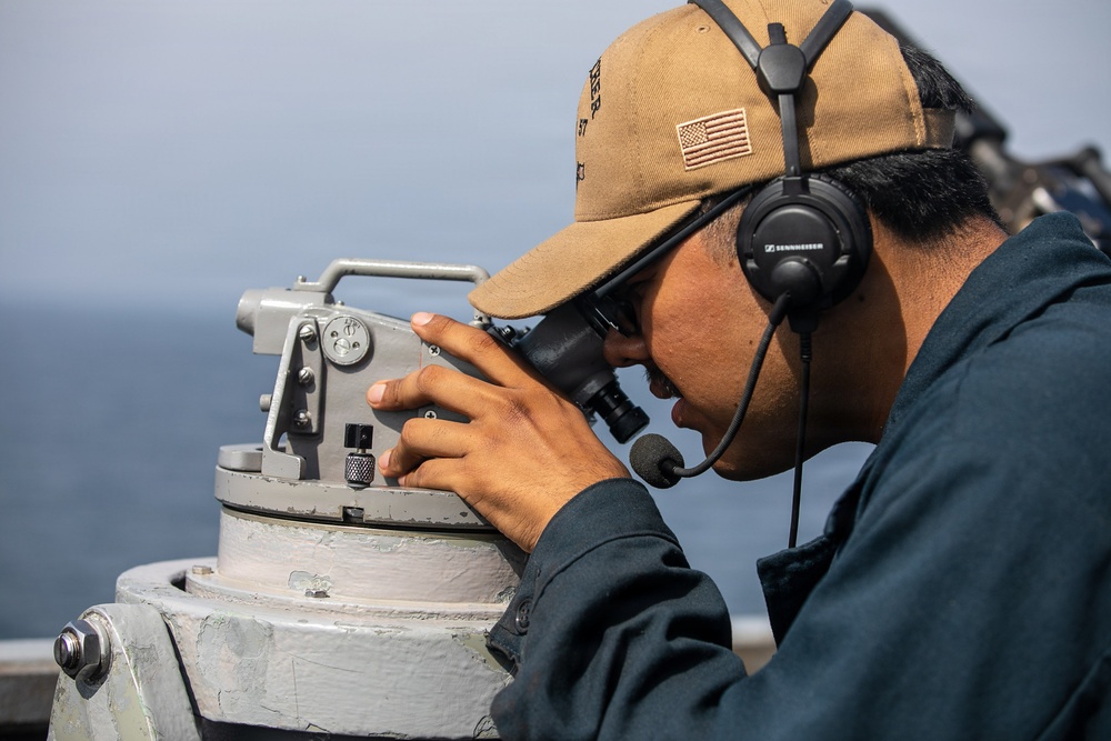 USS Mitscher (DDG 57) Sailor stands watch on bridge wing