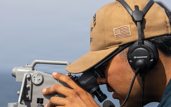 USS Mitscher (DDG 57) Sailor stands watch on bridge wing