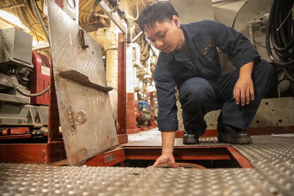 USS Mitscher (DDG 57) Sailor inspects valve in main machinery room