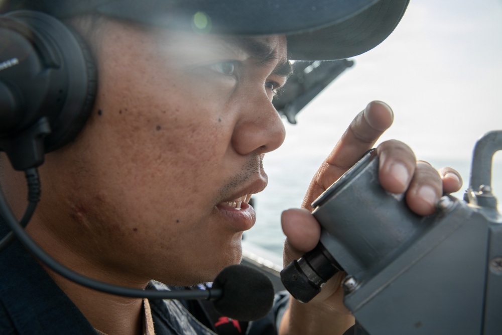 USS Mitscher (DDG 57) Sailor stands watch on bridge wing