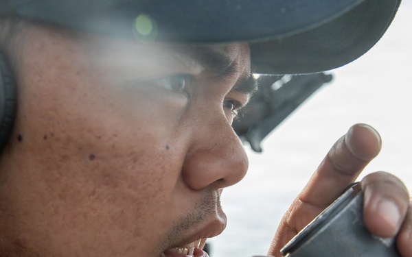 USS Mitscher (DDG 57) Sailor stands watch on bridge wing
