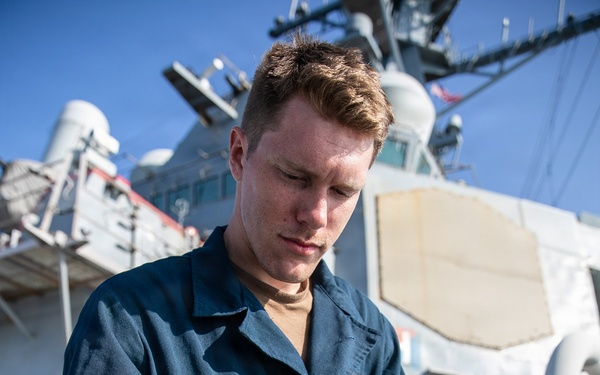 USS Mitscher (DDG 57) Sailor installs safety line on ship foc'sle