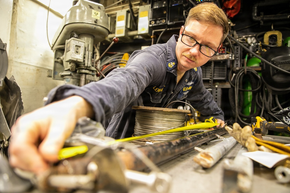 USS Mitscher (DDG 57) Chief measures stanchion in machine shop