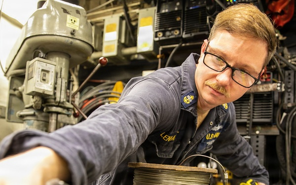 USS Mitscher (DDG 57) Chief measures stanchion in machine shop
