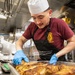 USS Mitscher (DDG 57) Sailor prepares food in ship galley