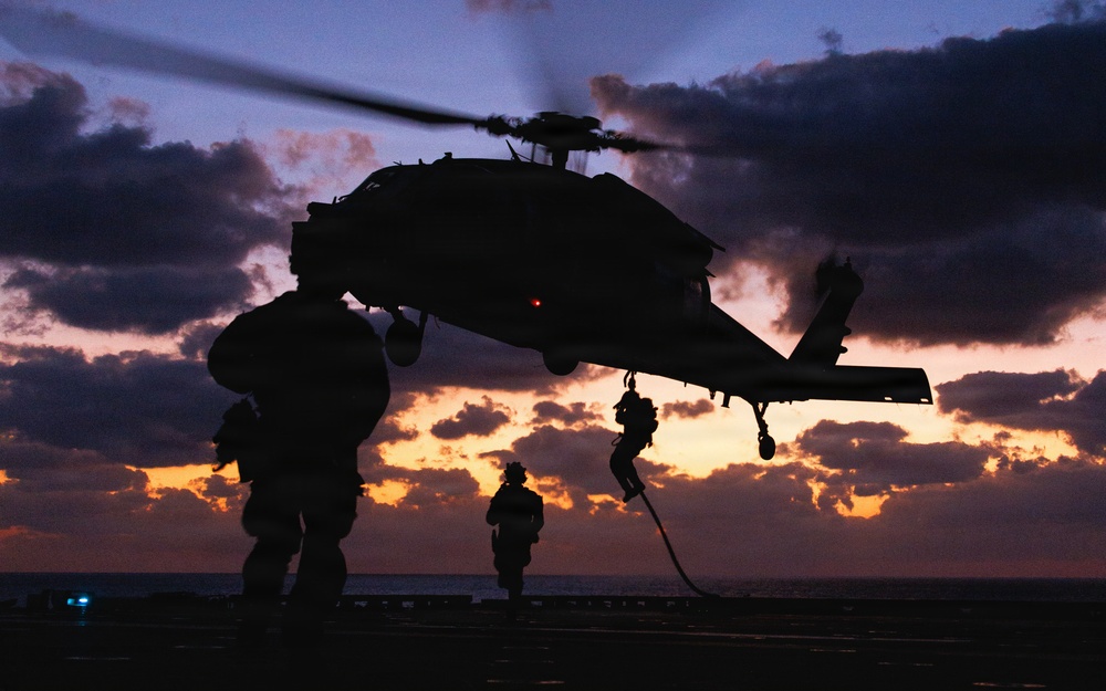U.S. Marines fast-rope from a helicopter during a maritime boarding exercise