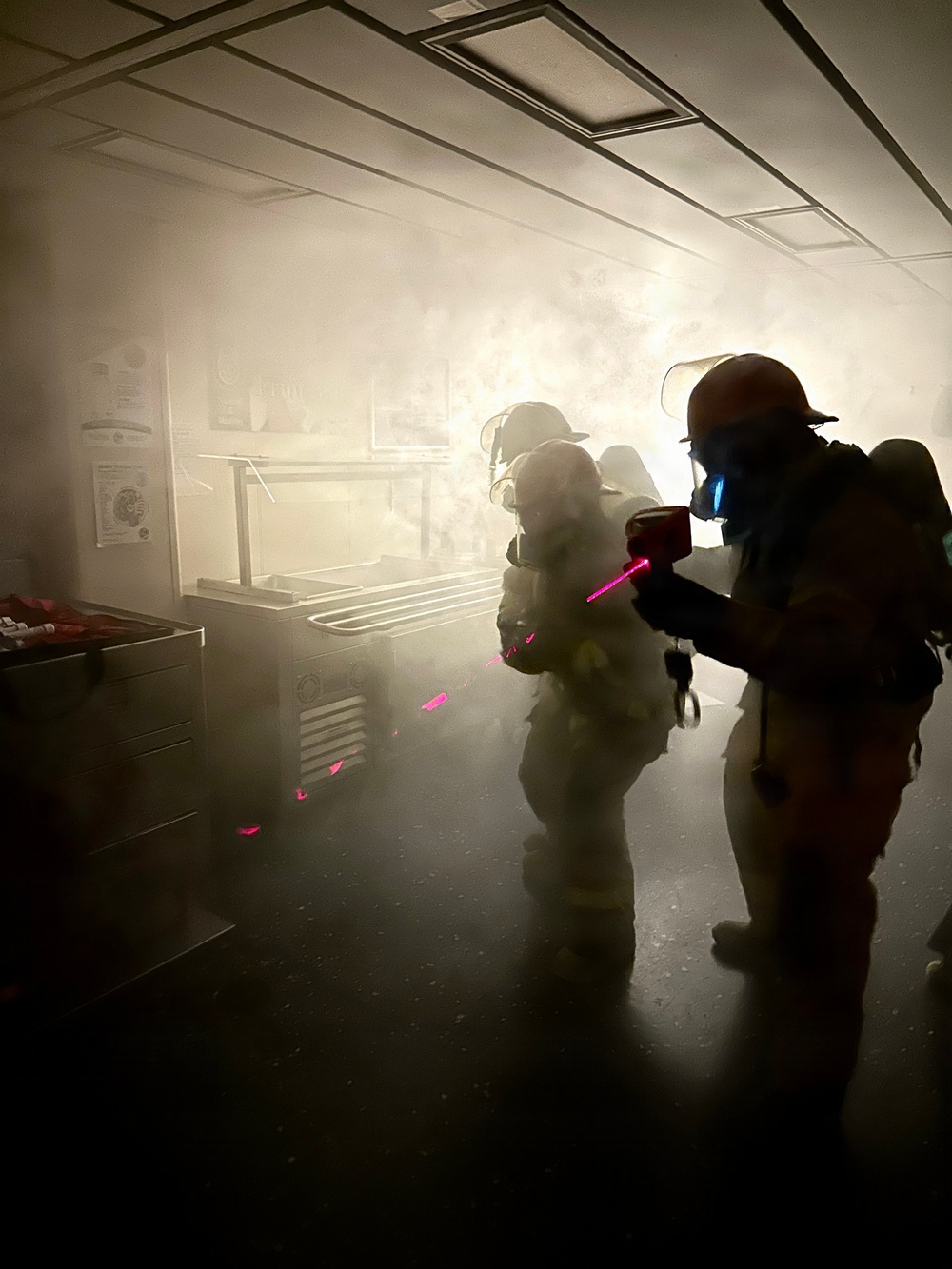 Aviation Boatswain's Mate Third Class Petty Officer Caleb Robinson uses a Naval Firefighting Thermal Imager (NFTI)