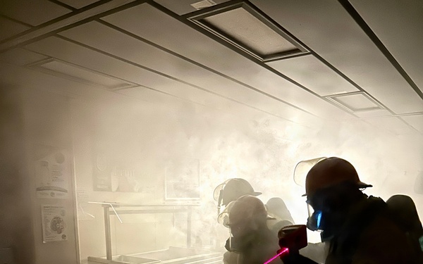 Aviation Boatswain's Mate Third Class Petty Officer Caleb Robinson uses a Naval Firefighting Thermal Imager (NFTI)