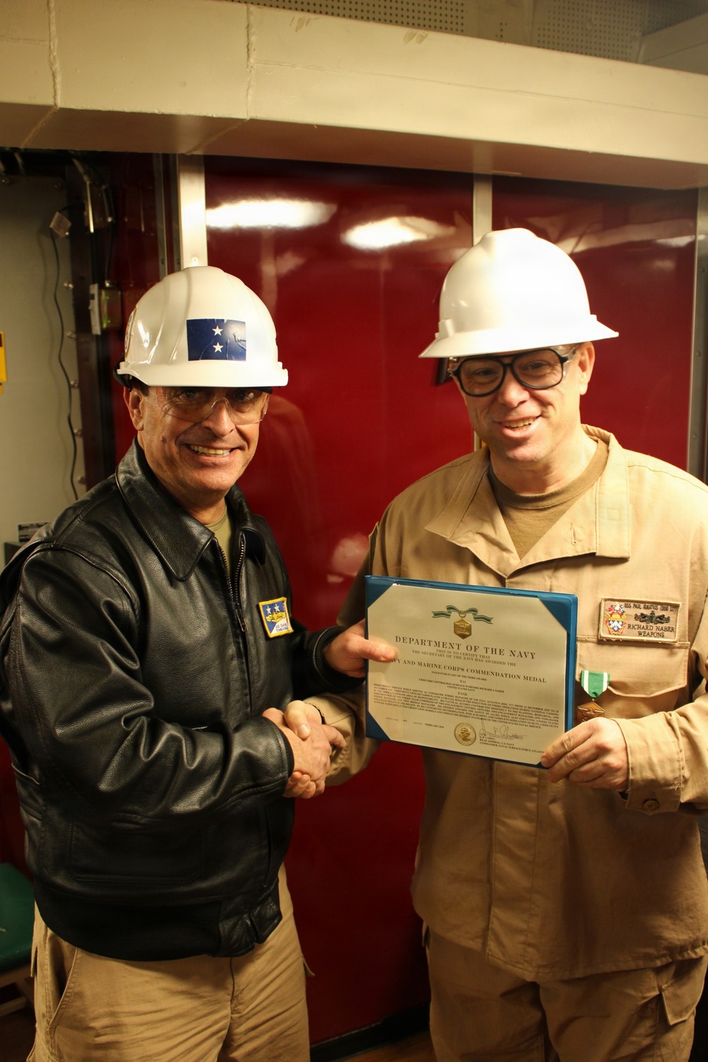 Rear Adm. Joe Cahill presents the Navy and Marine Corps Commendation Medal to Chief Fire Controlman Richard Naber