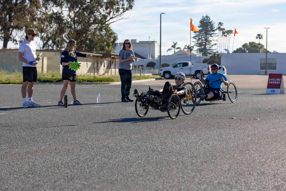 Sailors and Coast Guardsmen ride adaptive bicycles during timed trials