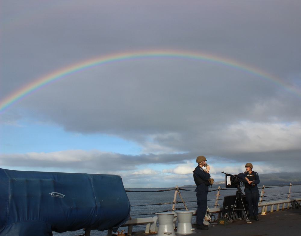 USS HOPPER Sailors standing watch with a rainbow in the background