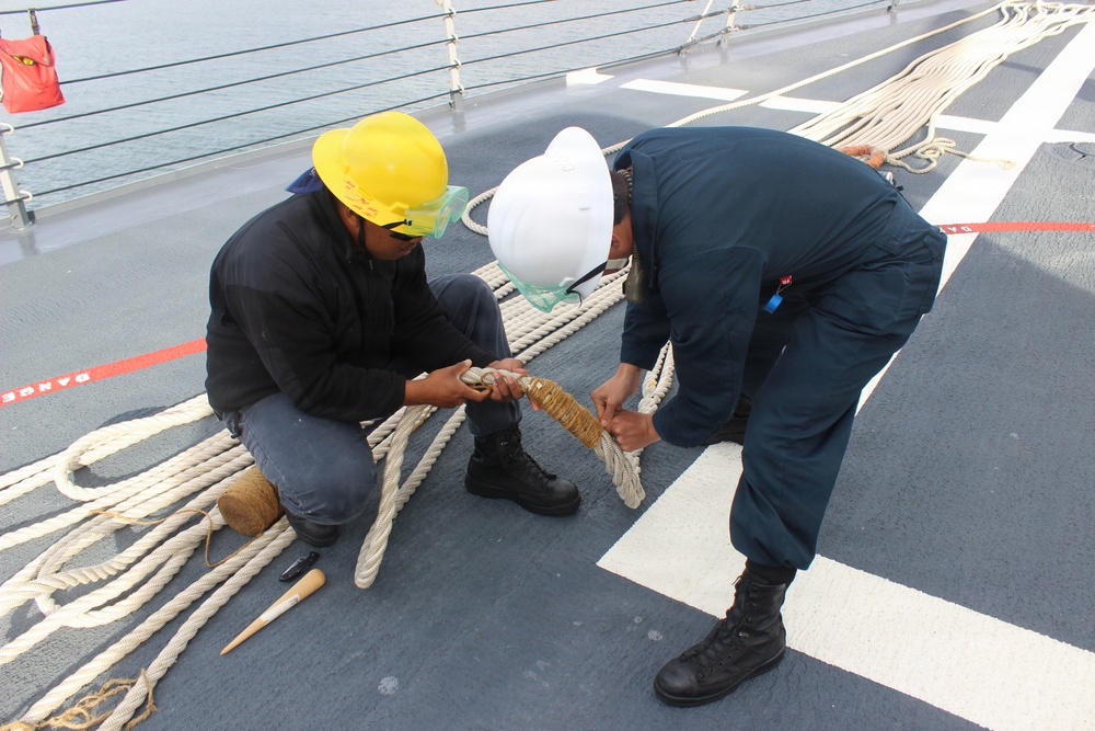 USS HOPPER Sailors making adjustments to a mooring line