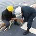 USS HOPPER Sailors making adjustments to a mooring line