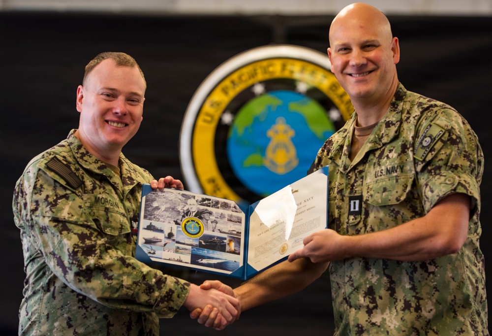 LT Joel Thiesfeldt presents Musician Second Class Benjamin Morgan with the Navy and Marine Corps Achievement Medal