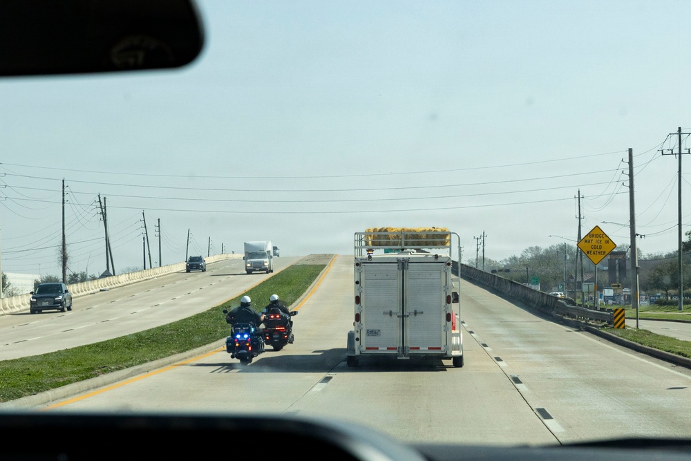 Police officers provide a motorcycle escort for the U.S. Marine Corps Mounted Color Guard to the Houston Livestock Show and Rodeo
