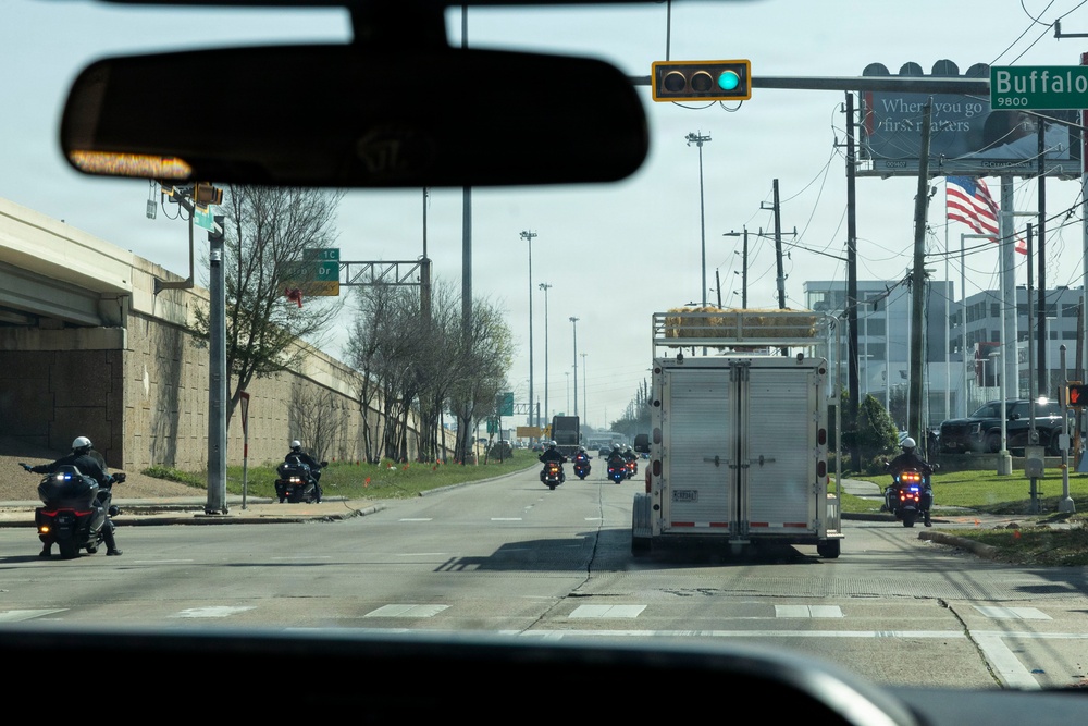 Police officers provide a motorcycle escort for the U.S. Marine Corps Mounted Color Guard to the Houston Livestock Show and Rodeo