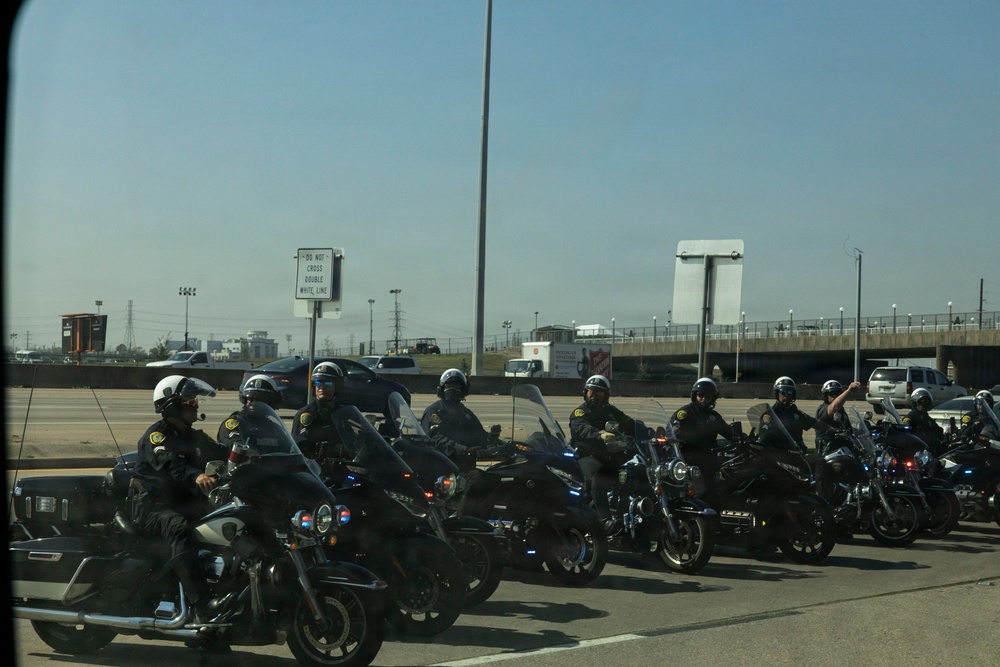 Police officers provide a motorcycle escort for the U.S. Marine Corps Mounted Color Guard to the Houston Livestock Show and Rodeo