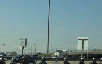 Police officers provide a motorcycle escort for the U.S. Marine Corps Mounted Color Guard to the Houston Livestock Show and Rodeo
