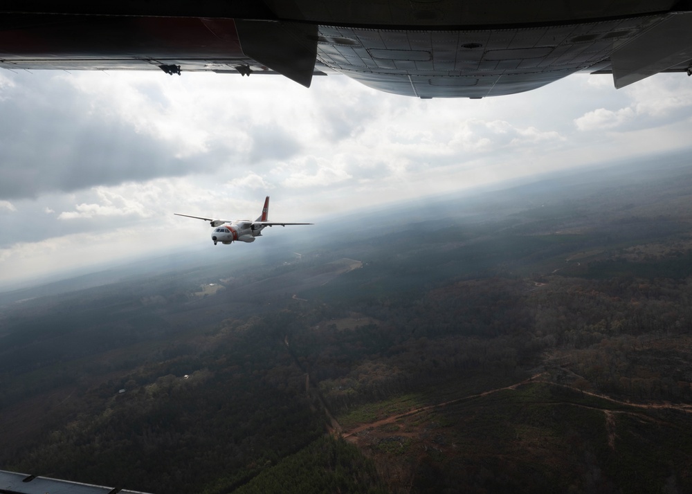A U.S. Coast Guard HC-144 Ocean Sentry flies over Auburn, Alabama