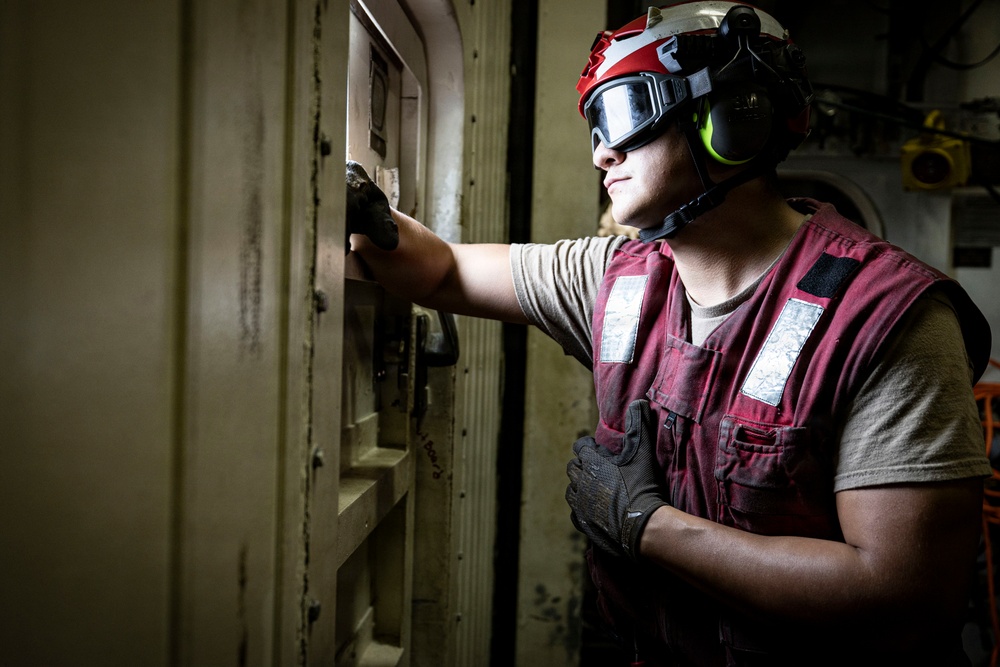 U.S. Sailor stands by for the arrival of an MH-60R Seahawk helicopter