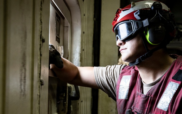 U.S. Sailor stands by for the arrival of an MH-60R Seahawk helicopter