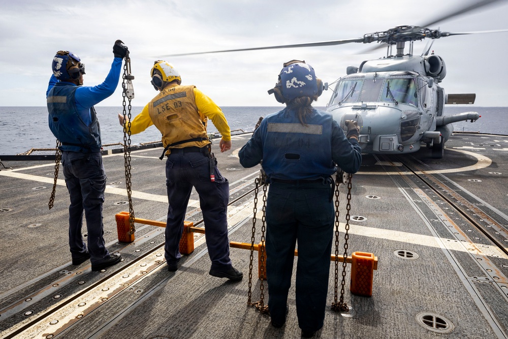 U.S. Sailors present chocks and chains to the pilots of an MH-60R Seahawk helicopter