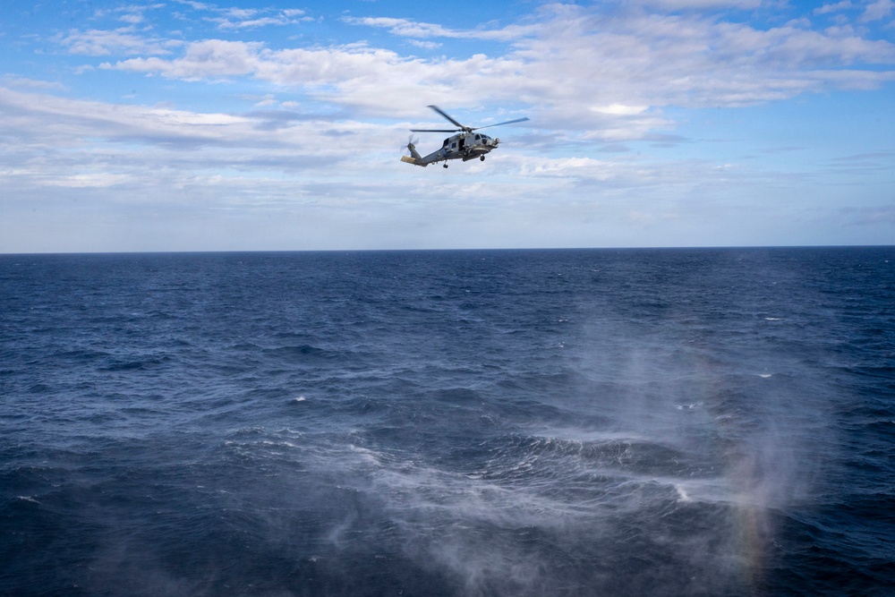 An MH-60R Seahawk helicopter conducts maritime interception maneuvers