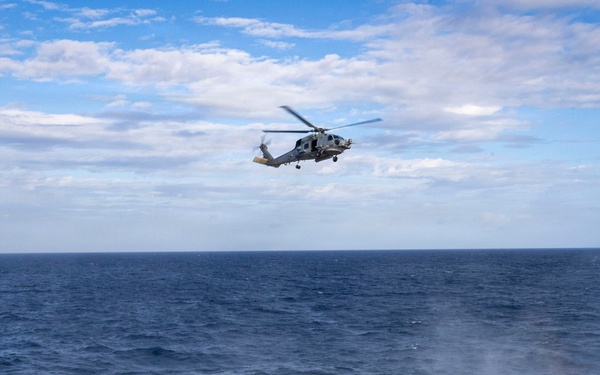 An MH-60R Seahawk helicopter conducts maritime interception maneuvers