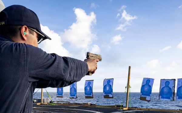 U.S. Sailor fires an M18 service pistol on the flight deck during a live-fire exercise
