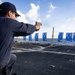 U.S. Sailor fires an M18 service pistol on the flight deck during a live-fire exercise