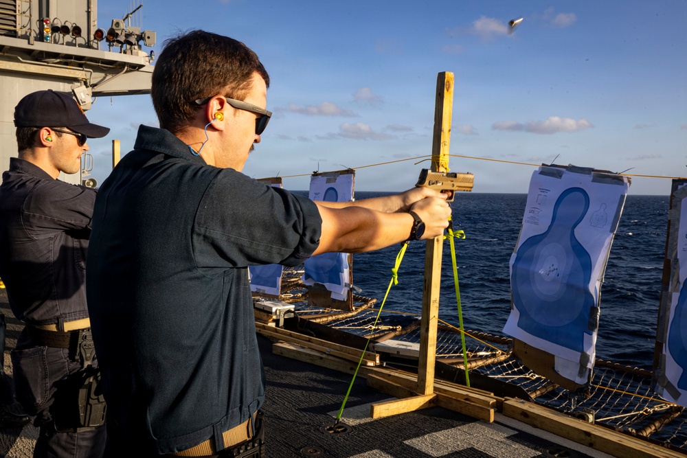 U.S. Sailor fires an M18 pistol on the flight deck during a live-fire exercise