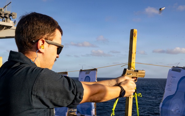 U.S. Sailor fires an M18 pistol on the flight deck during a live-fire exercise