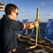 U.S. Sailor fires an M18 pistol on the flight deck during a live-fire exercise