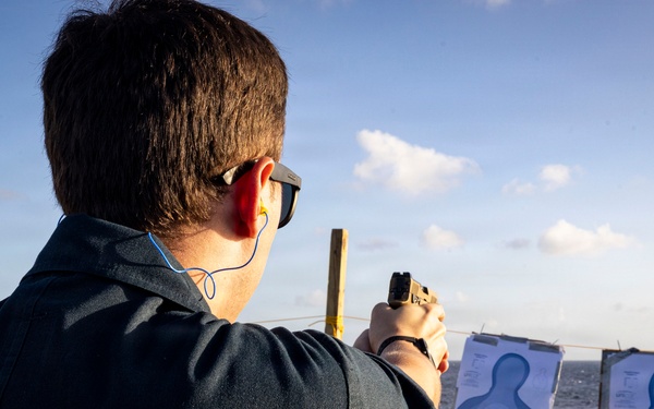 U.S. Sailor fires an M18 service pistol on the flight deck during a live-fire exercise