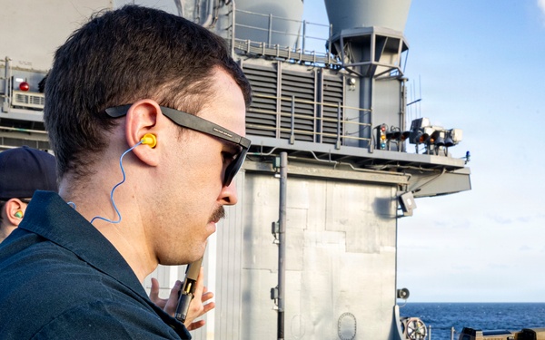 U.S. Sailor reloads an M18 pistol on the flight deck during a live-fire exercise