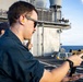 U.S. Sailor reloads an M18 pistol on the flight deck during a live-fire exercise