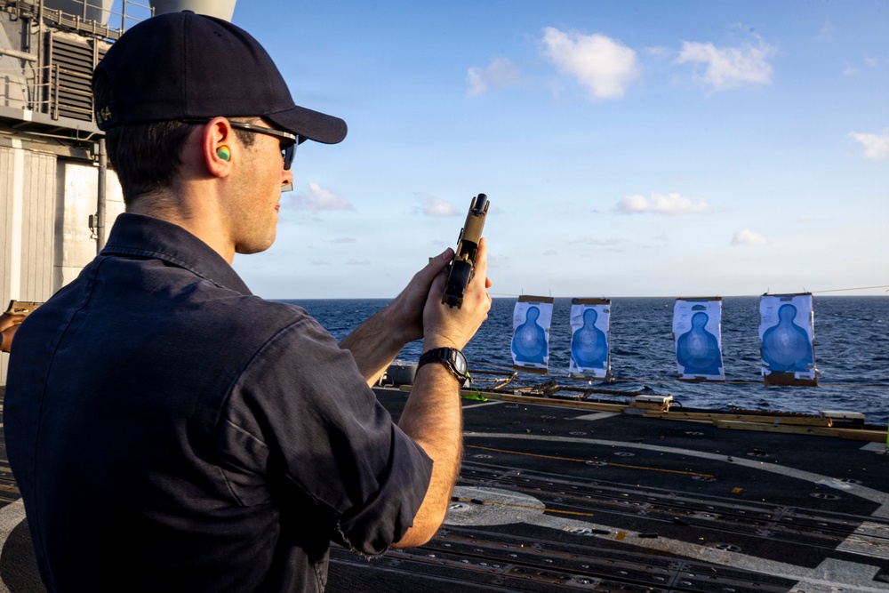 U.S. Sailor reloads an M18 pistol on the flight deck during a live-fire exercise