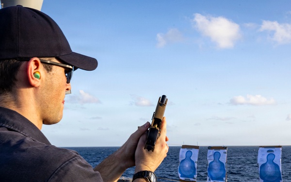 U.S. Sailor reloads an M18 pistol on the flight deck during a live-fire exercise