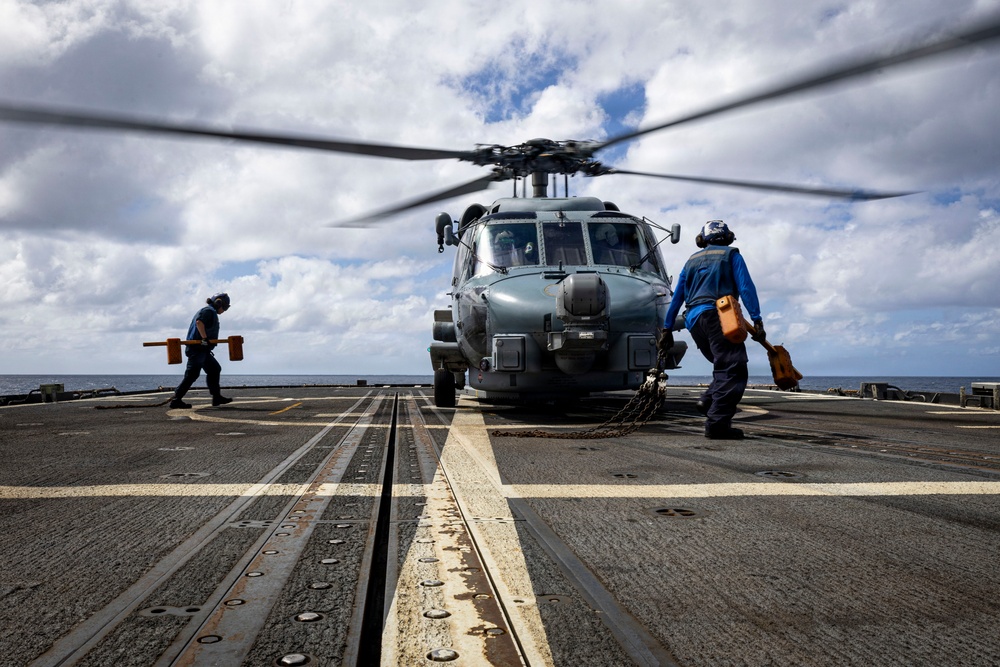 U.S. Sailors prepare to chock and chain an MH-60R Seahawk helicopter
