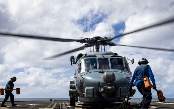 U.S. Sailors prepare to chock and chain an MH-60R Seahawk helicopter