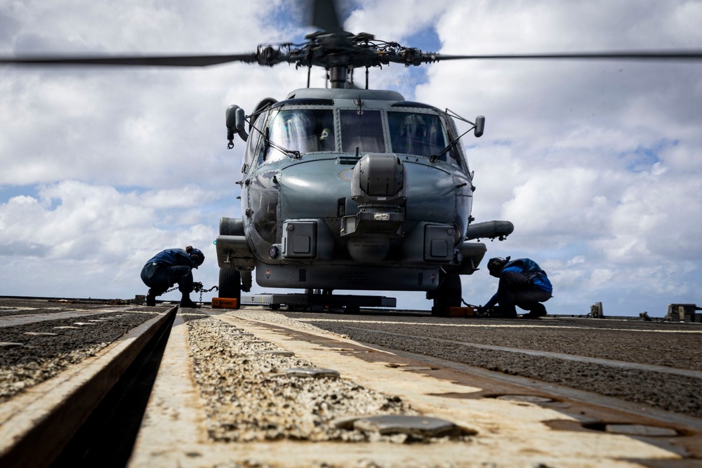 U.S. Sailors chock and chain an MH-60R Seahawk helicopter on the flight deck