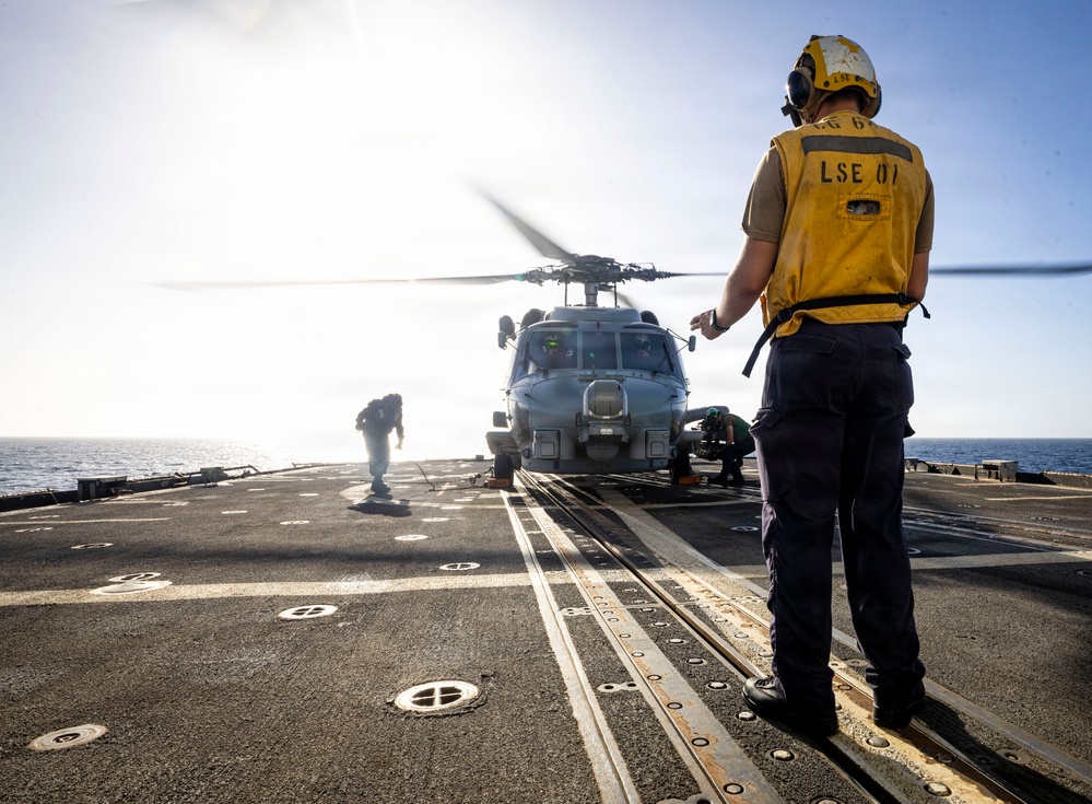 U.S. Sailors, assigned to the Iwo Jima Amphibious Ready Group, chock and chain an MH-60R