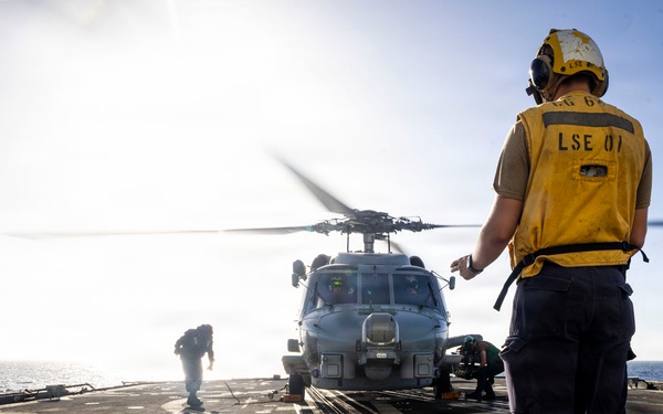 U.S. Sailors, assigned to the Iwo Jima Amphibious Ready Group, chock and chain an MH-60R