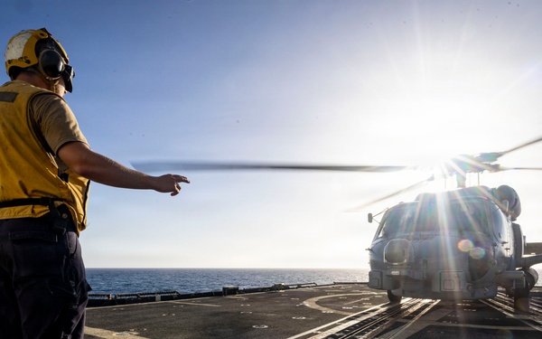 U.S. Sailor, assigned to the Iwo Jima Amphibious Ready Group, signals Sailors to remove chocks and chains